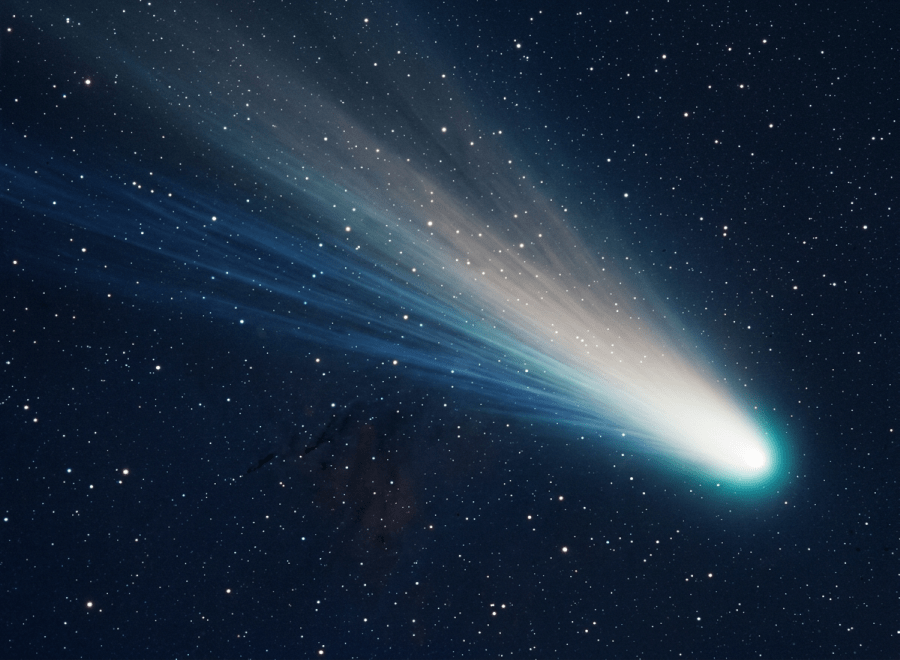 Bright comet with glowing blue and white tail against a starry night sky